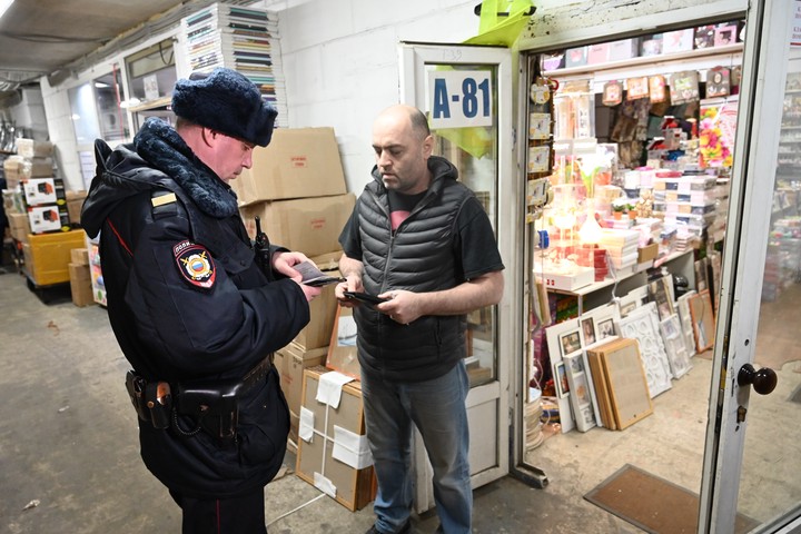 Старший сержант Денис Кабанов проверяет документы у продавца Рустама Урузбаева