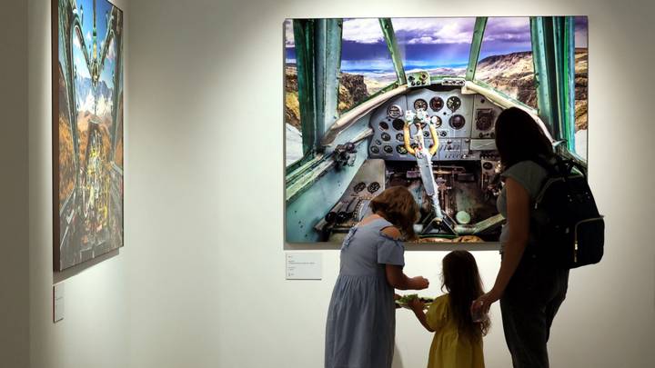 Семья у фотографии из серии «Управляемые небеса»