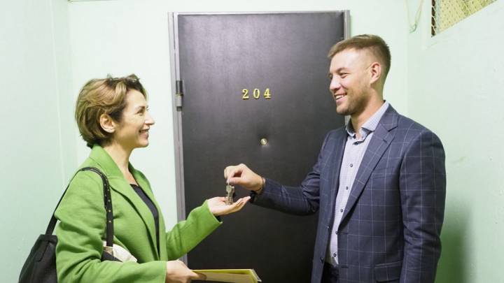 Столичный риелтор Олег Царев вручает ключи покупательнице квартиры Эльвире Шаровой