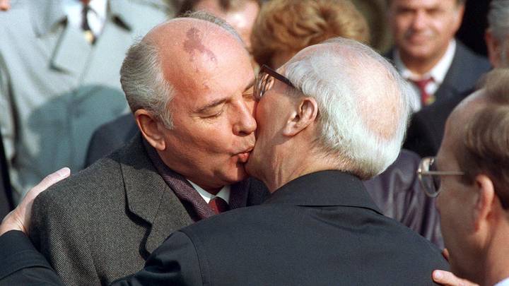 Presiden Soviet Mikhail Gorbachev (kiri) mencium pemimpin Jerman Timur Erich Honecker setelah tiba di Berlin Timur.  1989 / Foto: DPA/TASS