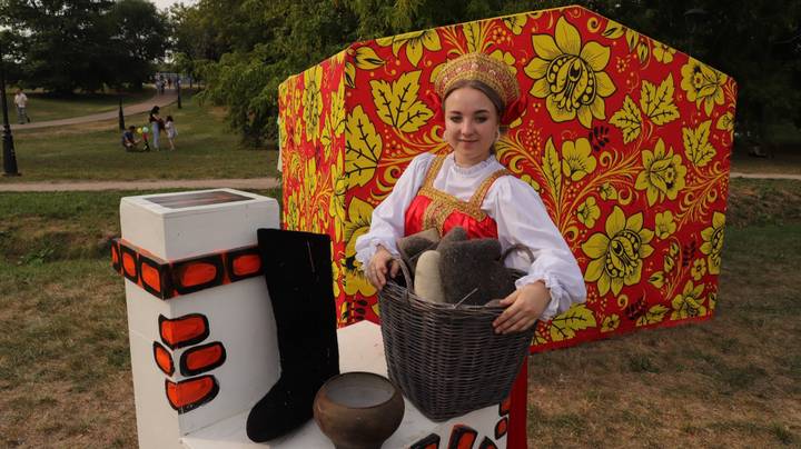 Участница фестиваля Анастасия Обухова встречает гостей мероприятия в русском национальном костюме