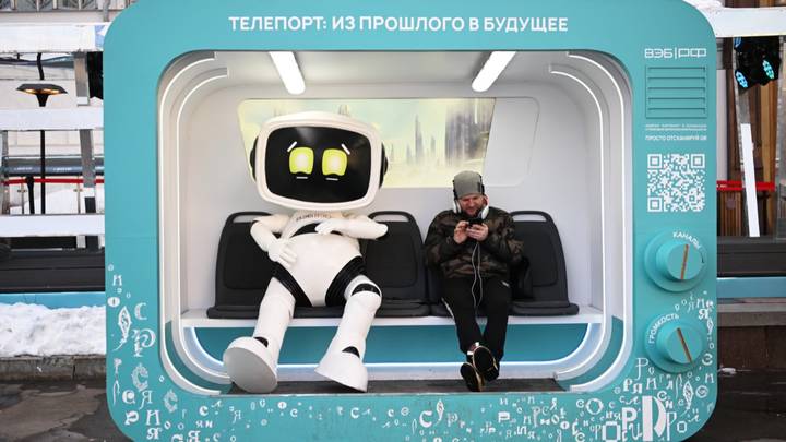 Посетитель выставки-форума «Россия» в капсуле с роботом