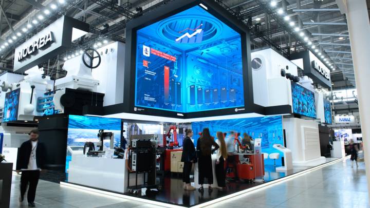 Посетители Международной промышленной выставки ИННОПРОМ-2024 у стенда Москвы рассматривают инновационные разработки столичных производителей