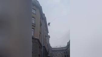 В Петербурге спустили дворника, который сорвался с крыши и повис на проводах