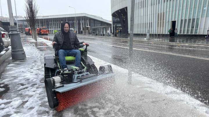 Руководитель компании Иван Рапоцевич проводит уборку улицы с помощью робота-снегоуборщика «Вектор»