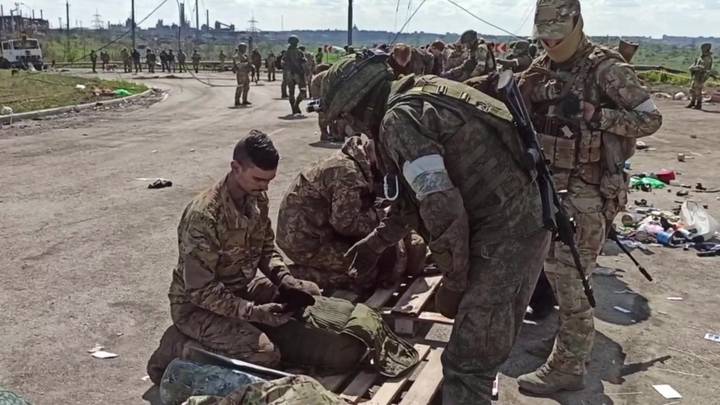 Российские военнослужащие досматривают сдавшихся в плен боевиков ВСУ и националистического батальона «Азов»* на территории комбината «Азовсталь» в Мариуполе